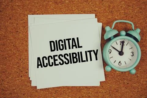 Digital Accessibility text on sticky note with alarm clock on cork paper ba.. Fotos de archivo