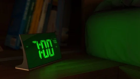 Digital alarm clock in a bedroom waking up at 7 AM Stock Footage 110573095