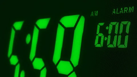 Digital alarm clock waking up at 6 AM. Close-up LED display. Stock Footage 98097166