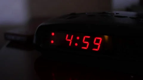 A digital alarm turns five and man turns off alarm Stock Footage 62443542