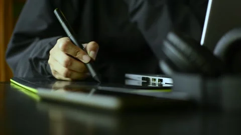 Digital artist using stylus on graphic tablet in modern workspace Stock Footage 209850729