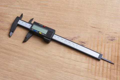 Digital caliper on a wooden surface for technical or industrial design. Pre.. Stock Photos