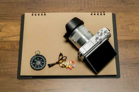 Digital Camera on Brown paper with compass and fish necklace Stock Photos