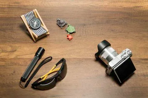 Digital camera with flash light and sun glass on wooden background Фото