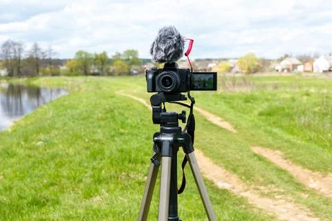 Digital camera with microphone on a tripod close-up. Mirrorless digital camer Stock Photos