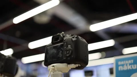 Digital camera on security stand displayed for sale in electronics store Stock Footage 345358908