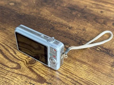 Digital camera on wooden table ready for use in bright light Stock Photos