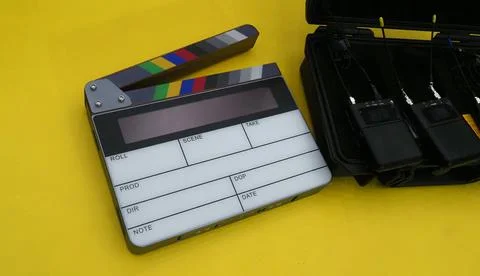 A digital clapperboard and a set of wireless microphone transmitters all pl.. Stock Photos