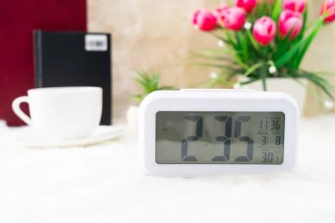 Digital clock and cup of coffee Stock Photos