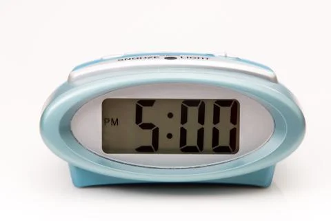Digital clock displaying 5:00 pm on white background. Stock Photos