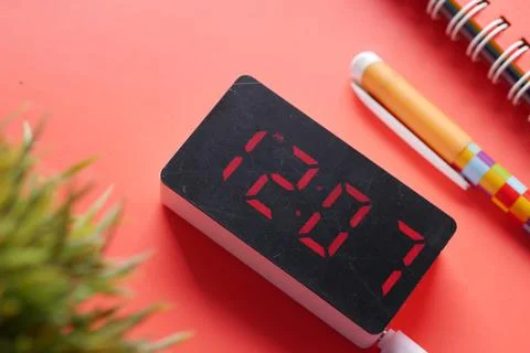 Digital clock on red background top down Stock Photos