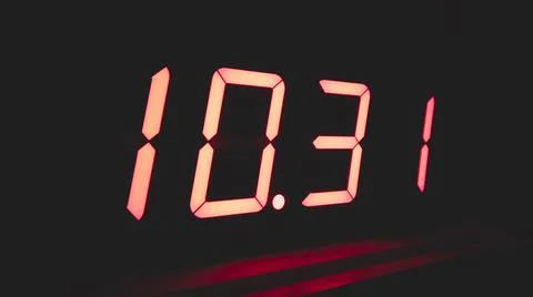 Digital clock with red led light illumination numbers in the dark. electronic Foto stock
