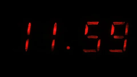Digital clock shows the time of 11 hours 59 minutes to 12 hours 00 minutes Stock Footage 71256095