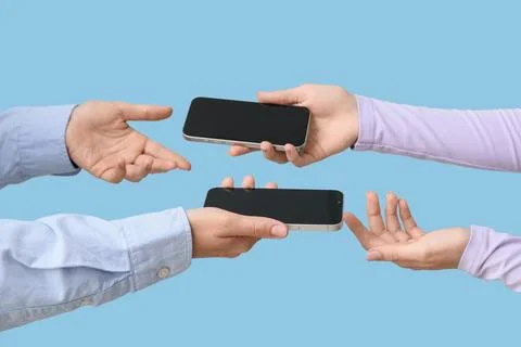 Digital communication and data transfer between people using modern smartphon Stock Photos