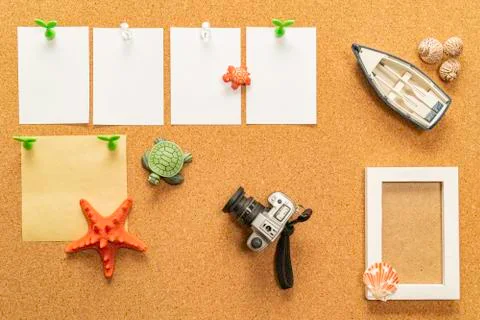 Digital compact camera on cork board with blank white paper, compass and boat Stock Photos