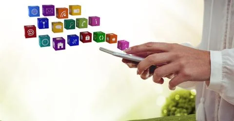 Digital composite of hand with phone with application icons coming up from it 写真素材