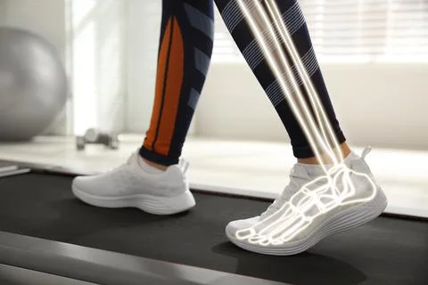 Digital composite of highlighted bones and woman training on walking treadm.. Fotos de archivo