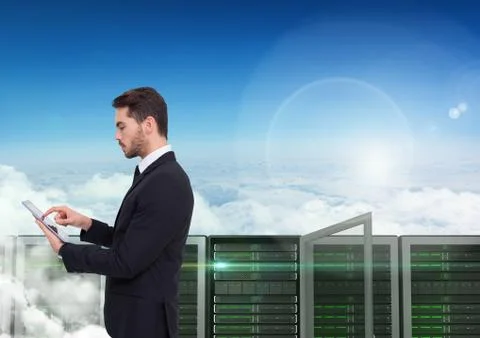 Digital composite image of businessman using digital tablet against server tower Stock Photos