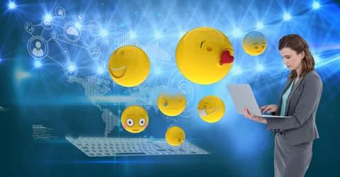 Digital composite image of emojis flying by businesswoman using laptop against Stock Photos