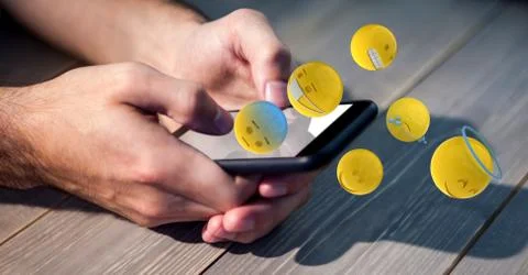 Digital composite image of hands using smart phone while emojis flying over Stock Photos