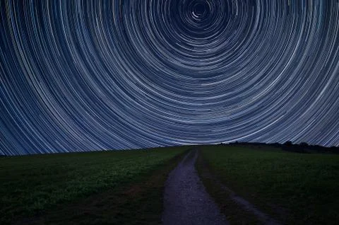 Digital composite image of star trails around Polaris with Countryside landsc Stock Photos