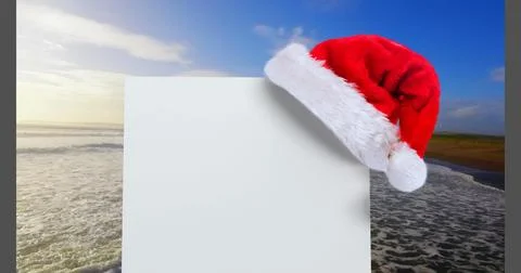 Digital composite of Santa hat with white card and sea Stock Photos