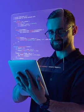 Digital composition. Smiling programmer with digital tablet and holographic code Foto stock