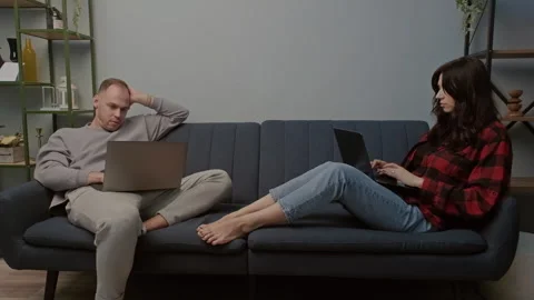 Digital couple works or studies on laptops in cozy home setting. Trendy concept Stock Footage 283853018