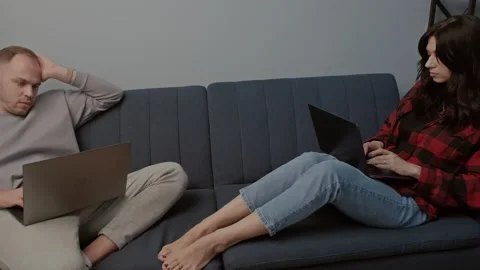 Digital couple works or studies on laptops in cozy home setting. Trendy concept Stock Footage 283853098