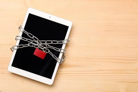 Digital data security and privacy with tablet, chain, and red padlock on wood Stock Photos