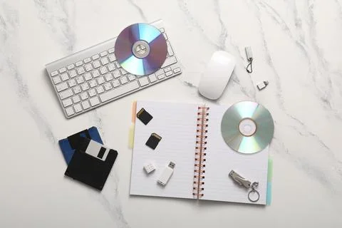 Digital data storage devices and computer peripherals on white marble desk, t Stock Photos