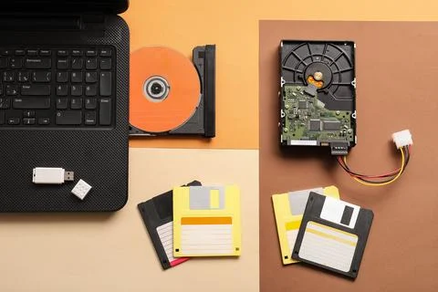 Digital data storage evolution: laptop, USB drive, CD-ROM, hard drive, and fl 库存照片