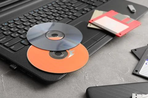 Digital data storage evolution: laptop with cds, floppy disks, USB drive, and 库存照片