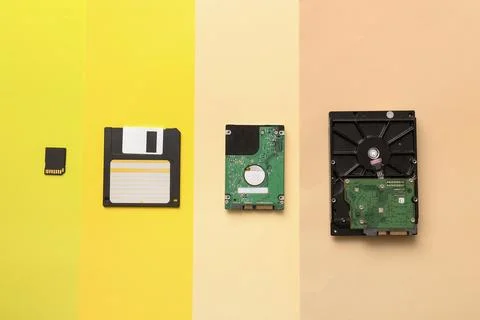 Digital data storage evolution: micro SD card, floppy disk, laptop hard drive 库存照片