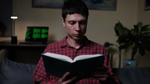 Digital Detox After Work. Young Man Reading a Book Instead of Laptop, Relaxing Video stock 318965869