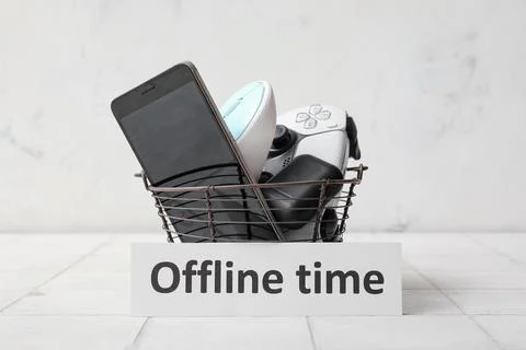 Digital detox with smartphone, game controller, and mouse in basket for offli Stock Photos