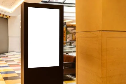 A digital display stand is positioned in a modern lobby area. The sleek desig Stock Photos