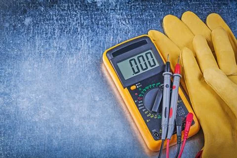 Digital electrical tester Test leads Protective gloves on scratched metallic Stock Photos