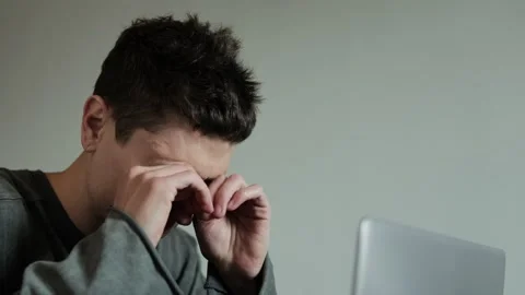 Digital eye strain. Close-up of exhausted young man taking off glasses massaging Stock Footage 308074678