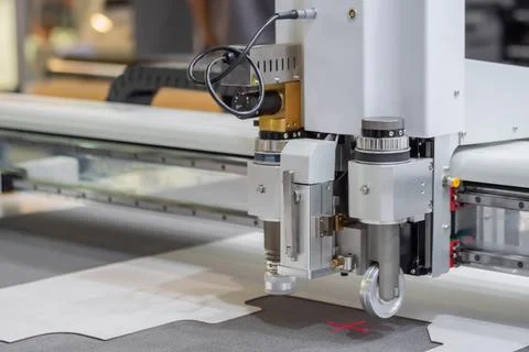 Digital flatbed cutter, plotter cutting white cardboard sheet at exhibition Stock Photos