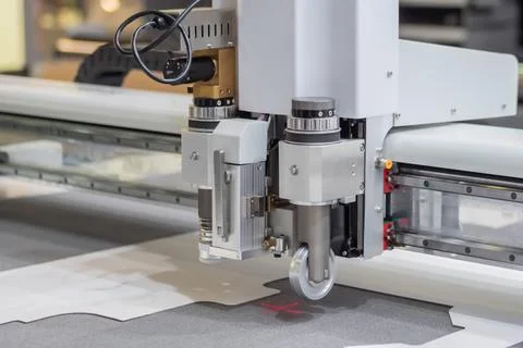 Digital flatbed cutter, plotter cutting white cardboard sheet at exhibition Stock Photos