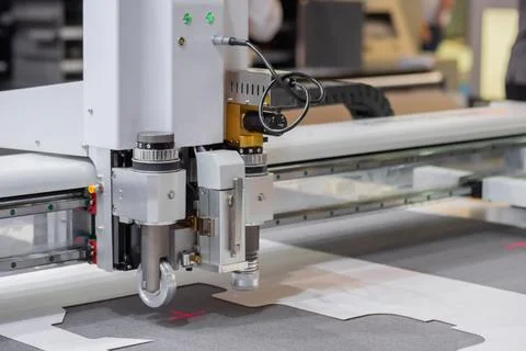 Digital flatbed cutter, plotter cutting white cardboard sheet at exhibition Stock Photos