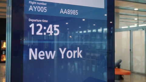 Digital flight information display showing departure time 12:45 for flight AY005 스톡 동영상 329201743