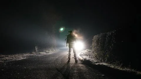 A digital glitch effect of a man standing on a road on a winters night. Stock Photos