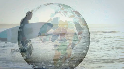 Digital globe fading over sunset showing travel tech bubble as surfer entering Stock Footage 313677777