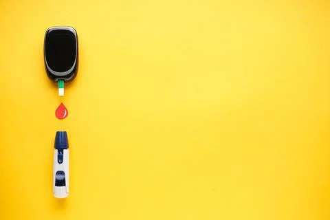 Digital glucometer and lancet pen on yellow background with space for text. D Stock Photos