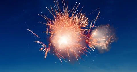Digital image of red fireworks exploding in the blue sky Stock Photos