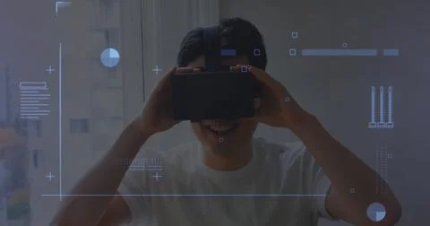 Digital interface with data processing against asian man wearing vr headset at 写真素材