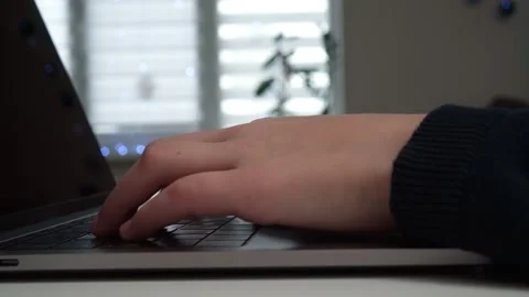 Digital laptop computer on home table, side view closeup. Hands of young guy Stock Footage 233770572