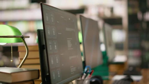 Digital learning screens on computer monitors placed on library study desk Stock Footage 337230118